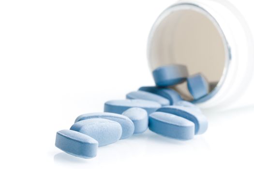 blue medical pills in laboratory near white container on white table