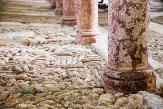 antique red marble columns resting on stone floor