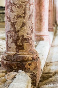 antique red marble columns resting on stone floor