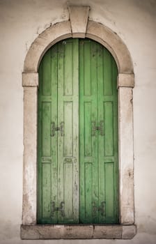 Ancient stone window with green wooden balcony