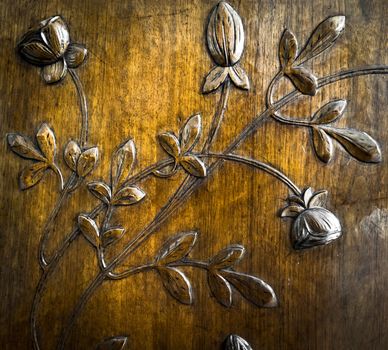 leaves and flowers carved in the wood of an antique dresser