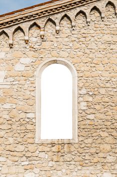 Arched window in the ancient medieval stone wall suitable as a frame or border.