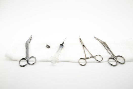 surgical composition with forceps, scissors, syringe and bullet