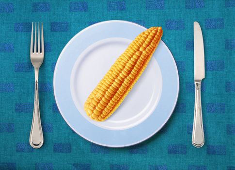 corn on white plate with knife and fork