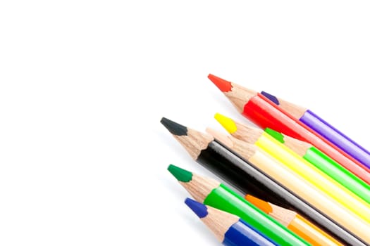 close up of a colorful pencils in a corner on white background