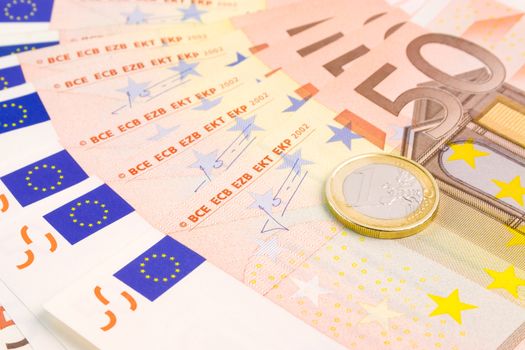 detail of euro coin on 50-euro banknotes on white background