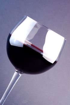 a glass of wine on a light purple background