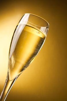 a champagne flute against a golden background with space for text