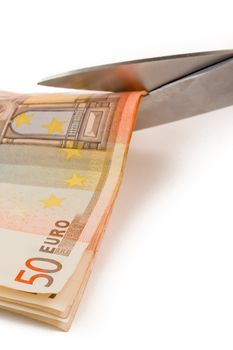 detail of used banknotes of euro and scissors on white background