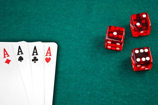 poker card and dice in corner in of a green fabric background 