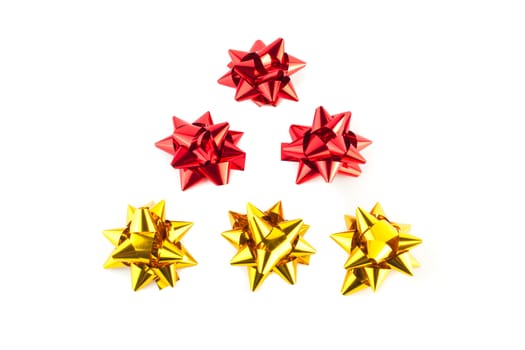 detail of a christmas tree of gold and red bows on white background