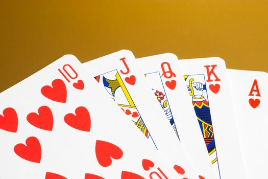 detail of a royal flush of hearts on gold background