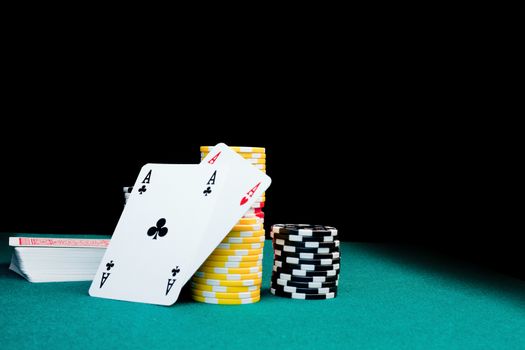 Gambling chips, a stack of cards & two aces