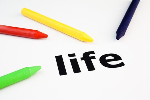 Detail view of colored wax crayons arranged on the word life