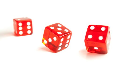 detail of  two red dice and one unfocused on white background