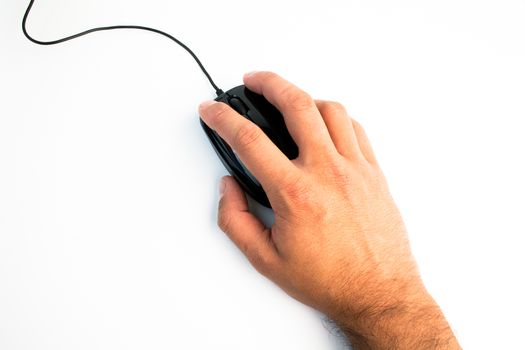 close up of black computer mouse with hand over white table