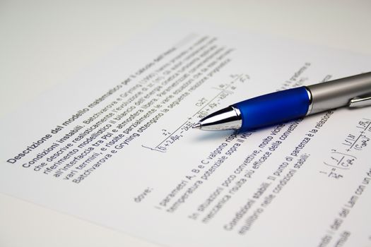 Detail view of  scientific paper image with a pen lying