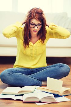 education and home concept - smiling student girl in eyeglasses reading books at home