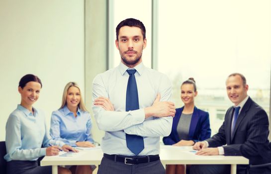 business and office concept - handsome businessman with crossed arms