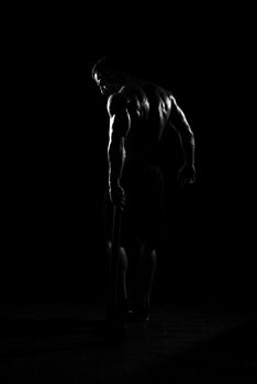 Man Walking Alone With Hammer In Dark Room