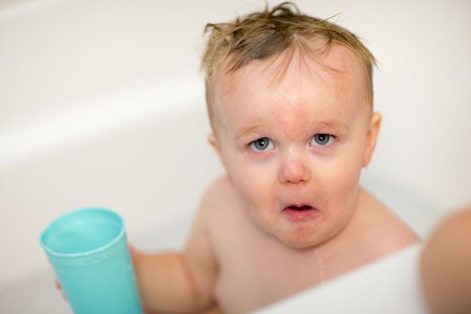 Little guy makes one interesting face while getting a bath