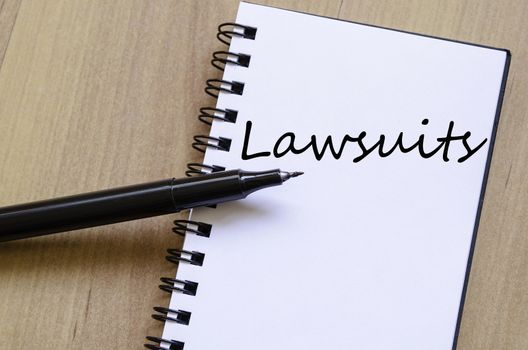 Notepad and pen on wooden background and text concept