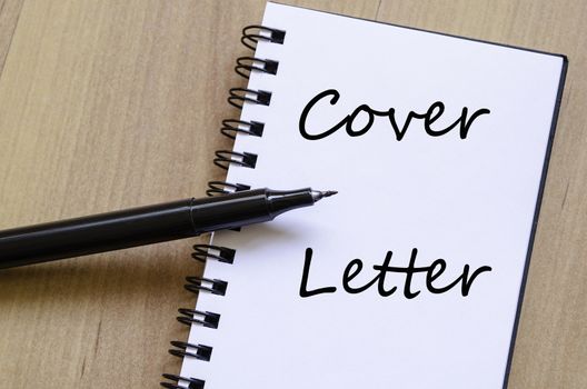 Notepad and pen on wooden background and text concept