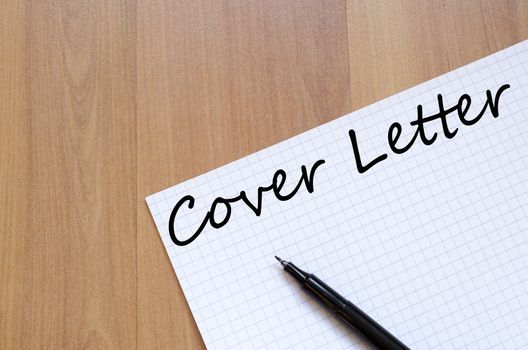 Notepad and pen on wooden background and text concept
