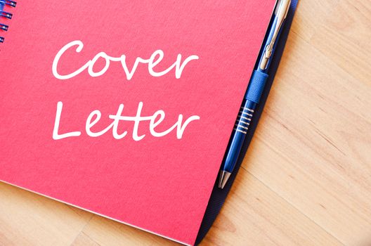 Notepad and pen on wooden background and text concept