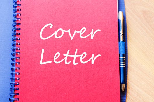 Notepad and pen on wooden background and text concept