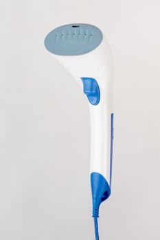 Image hand domestic garment steamer in three quarters, isolated on a light background