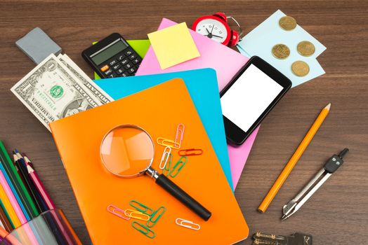 Colorful copybooks with office suppleis on wooden table