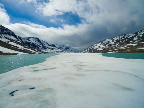 Ice on frozen lake in norwegian mountains on Gamle Strynefjellsvegen mountain pass
