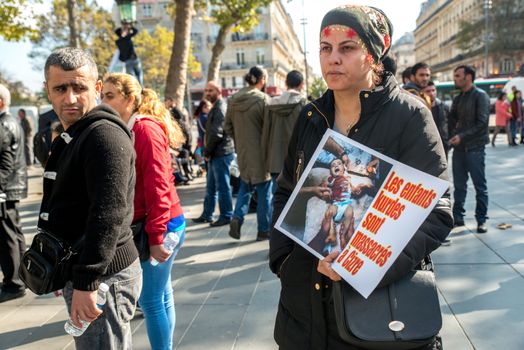 FRANCE, Paris: Two women stand holding a picture of Ankara terror attack while protesters gather in Place de la R�publique in Paris on October 10, 2015, in tribute to the victims of the terror attack. The same day, at least 95 people died after a twin explosion in the center of the capital city in Turkey. 