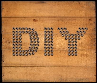 Many screws in the shape of text Diy (Do it yourself), on a brown wooden background with nails. isolated on black background