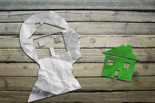 Paper humans head with house symbol on wood deck background