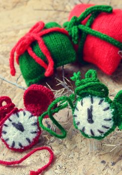 Amazing christmas background, handmade clock in red and green color, colour of xmas seasonal, ornament for winter holiday with knitted watch, gift, pine cone, nice decor