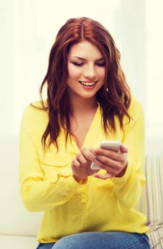 home, technology and internet concept - smiling woman with smartphone sitting on couch at home