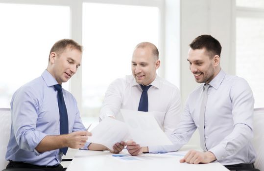 business and office concept - smiling businessmen with papers in office