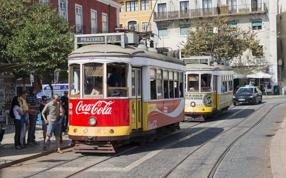 LISBON, PORTUGAL - SEPTEMBER 26: Unidentified people getting on  the Yellow tram  goes by the street of Lisbon city center on September 26, 2015. Lisbon is a capital and must famous city of Portugal