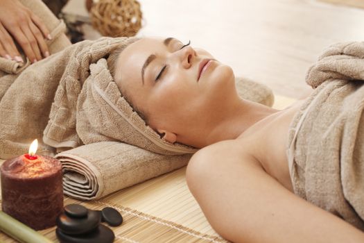 Beautiful young woman relaxing in spa salon