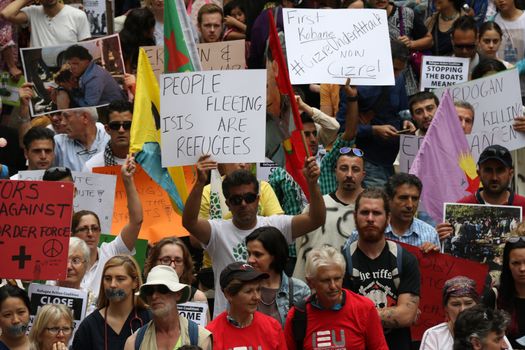 AUSTRALIA, Sydney: #StandUp4Refugees protesters carry signs as they march to Belmore Park after a rally at Sydney Town Hall on October 11, 2015; thousands demonstrate across Australia to support asylum seekers and oppose mandatory detention.