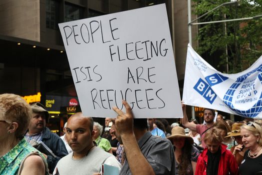 AUSTRALIA, Sydney: #StandUp4Refugees protesters carry signs as they march to Belmore Park after a rally at Sydney Town Hall on October 11, 2015; thousands demonstrate across Australia to support asylum seekers and oppose mandatory detention.
