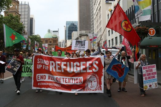 AUSTRALIA, Sydney: #StandUp4Refugees protesters carry signs as they march to Belmore Park after a rally at Sydney Town Hall on October 11, 2015; thousands demonstrate across Australia to support asylum seekers and oppose mandatory detention.