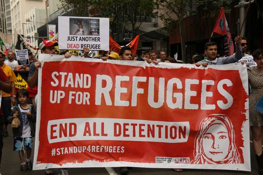 AUSTRALIA, Sydney: #StandUp4Refugees protesters carry signs as they march to Belmore Park after a rally at Sydney Town Hall on October 11, 2015; thousands demonstrate across Australia to support asylum seekers and oppose mandatory detention.