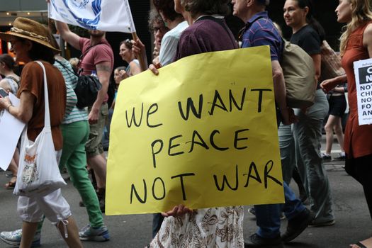 AUSTRALIA, Sydney: #StandUp4Refugees protesters carry signs as they march to Belmore Park after a rally at Sydney Town Hall on October 11, 2015; thousands demonstrate across Australia to support asylum seekers and oppose mandatory detention.