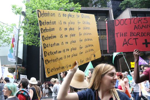 AUSTRALIA, Sydney: #StandUp4Refugees protesters carry signs as they march to Belmore Park after a rally at Sydney Town Hall on October 11, 2015; thousands demonstrate across Australia to support asylum seekers and oppose mandatory detention.