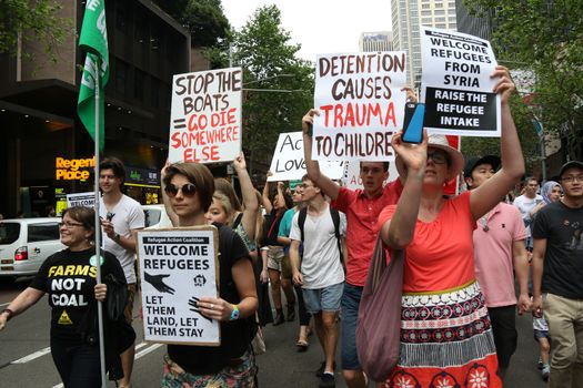 AUSTRALIA, Sydney: #StandUp4Refugees protesters carry signs as they march to Belmore Park after a rally at Sydney Town Hall on October 11, 2015; thousands demonstrate across Australia to support asylum seekers and oppose mandatory detention.
