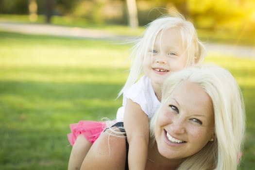 Pretty Mother and Little Girl Having Fun Together in the Grass.