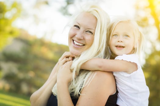 Pretty Mother and Little Girl Having Fun Together in the Grass.